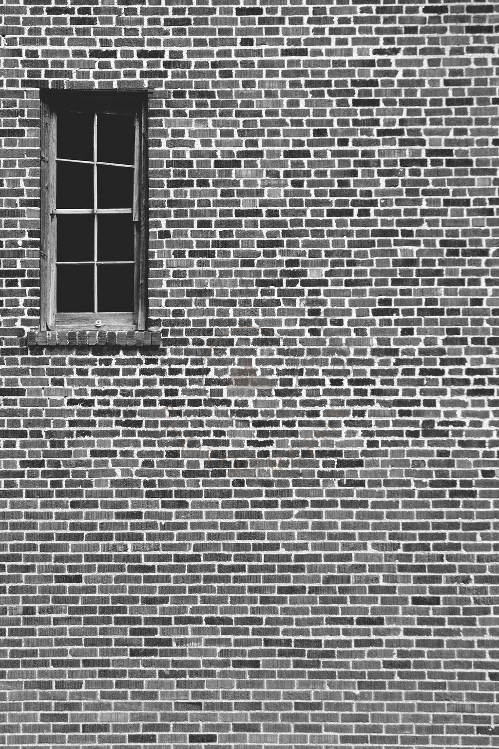 Single dark window in an old brick wall